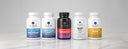 Five Dr. Emil supplement bottles on a light gray background