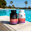Two bottles of Dr. Emil Nutrition supplements by a pool with palm trees in the background.
