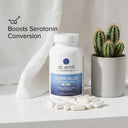 Bottle of dr. emil 5-HTP Plus supplement with pills on a white surface next to a cactus.
