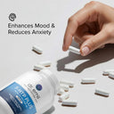 Hand picking a supplement capsule from a bottle labeled 'dr. emil 5-HTP PLUS' with text 'Enhances Mood & Reduces Anxiety' on a light background.