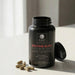 Black supplement bottle labeled 'Dr. Emil Bedtime Burn Elite' on a light surface with scattered capsules.