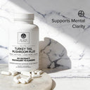 Supplement bottle labeled 'Turkey Tail Mushroom Plus' by Dr. Emil Nutrition on a marble surface.