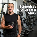 Man holding a supplement container in a gym with text 'Synergistic N.O. Booster Stack'.