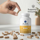 Bottle of Dr. Emil Lion's Mane supplement with capsules and a hand holding a capsule on a light background.