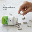 Hand picking up a supplement capsule from an open bottle labeled 'Liver Support' by Dr. Emil on a marble surface.