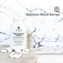 Menopause support supplement bottle with pills on a marble surface, labeled 'Stabilizes Mood Swings'.