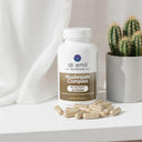 Dr. Emil Nutrition Mushroom Complex supplement bottle with capsules on a white surface next to a cactus plant.