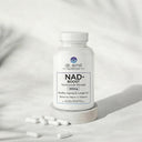 Dr. Emil NAD+ Boost supplement bottle with scattered capsules on a light background