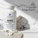 Dr. Emil Nutrition NMN supplement bottle with capsules on a marble surface, labeled for cellular energy support.