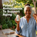 Woman holding a bottle of Resveratrol Plus with text about potent antioxidants to support aging.