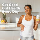 Woman holding a supplement bottle with text 'Get Good Gut Health Every Day' in a kitchen setting.