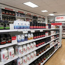 Shelves stocked with various health and fitness products in a GNC store.